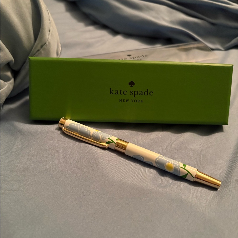 Kate Spade Ballpoint Pen- writes with black ink. The Pen itself is 5 1/2” long.